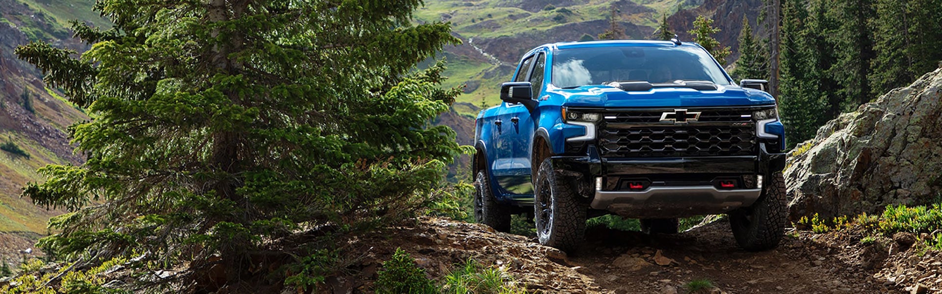 blue Chevrolet Silverado 1500 offroading on mountain